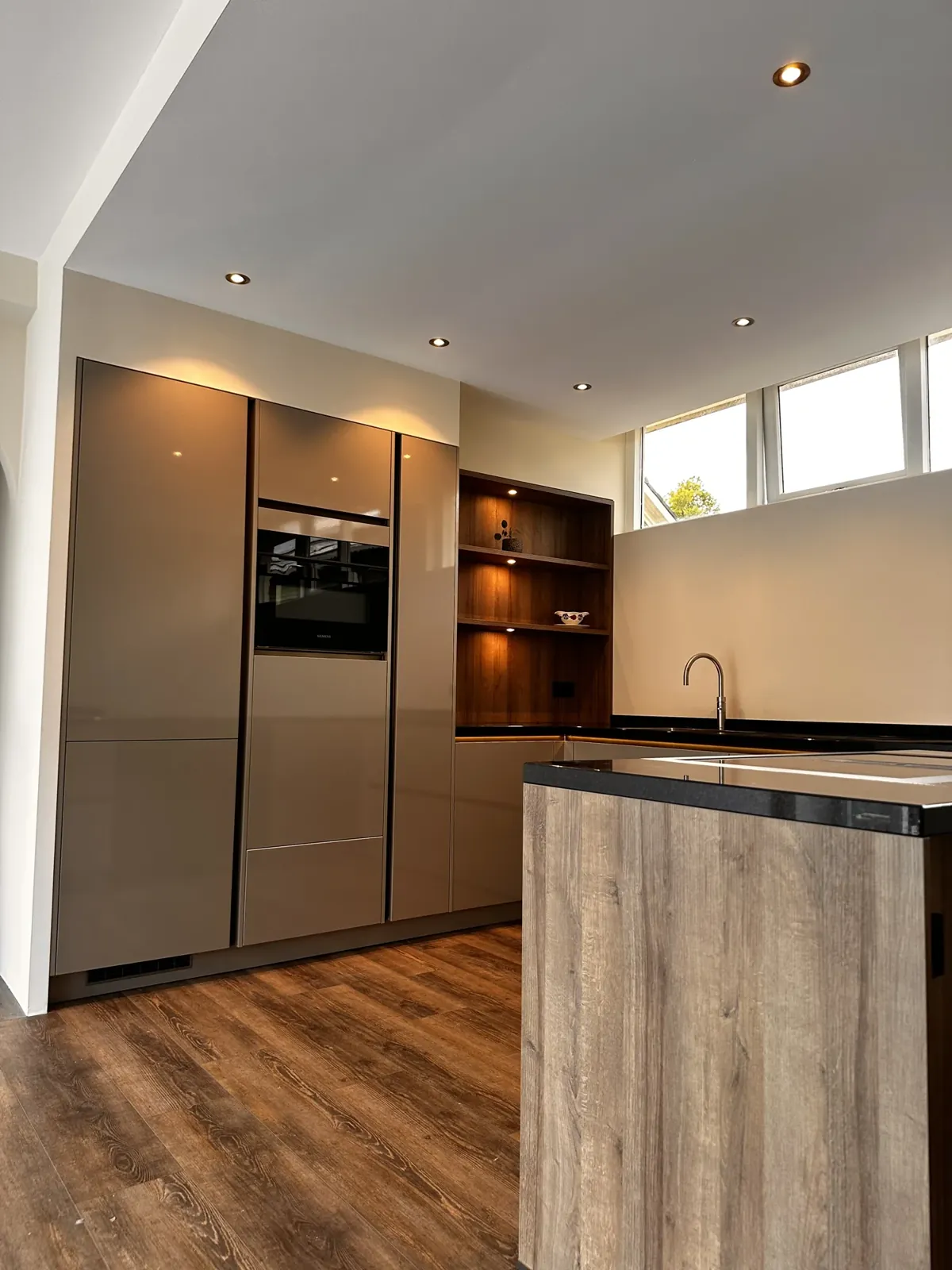 Keuken op maat Boskoop: hoge kastenwand met inbouwoven en open houten vakken