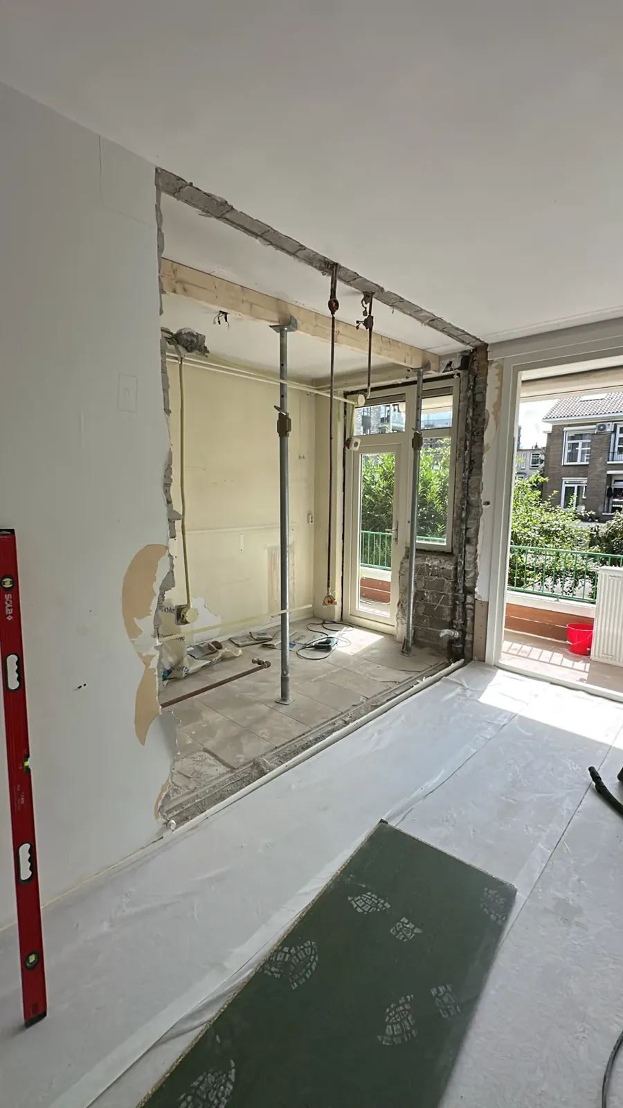 Keukenrenovatie Den Haag: muur tussen keuken en woonkamer weggehaald, stempels onder het plafond